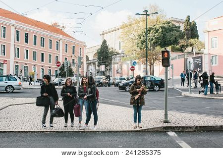 Lisbon, Portugal 01 May 2018: Pedestrians Cross Street. Girls Or Company Of Friends Stand On Interse