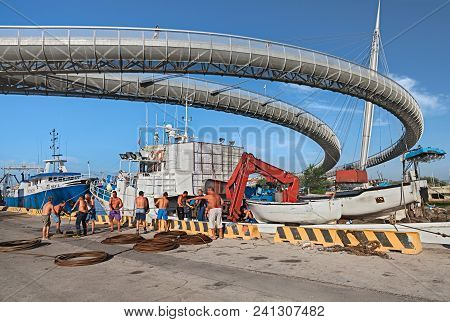 Pescara, Italy - September 15: Workers In The Harbor Unload A Heavy Steel Rope From A Ship; Above Th