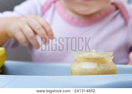 Child In The Kitchen Eating Fruit Puree, Shallow Depth Of Field, Selective Focus.