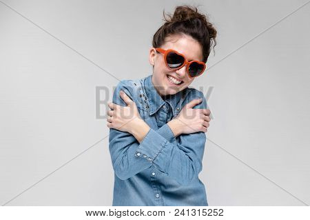 Young Girl With Glasses In Heart On Gray Background. Portrait Of A Young Beautiful Girl. Charming Gi