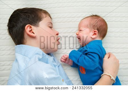 Big Brother Hugging His Newborn Baby. Toddler Kid Meeting New Sibling. Cute Boy And New Born Baby Gi