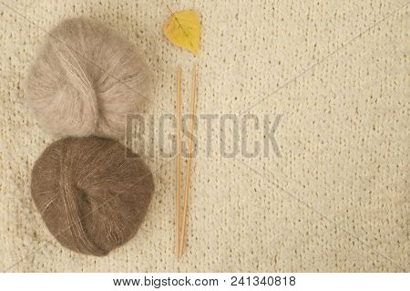 Knitting Yarn With Knitting Needles On Wooden Table, On Light Background