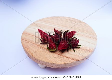 Rosella Or Hibiscus Or Kharkade Or Malvaceae Or Sorrel Seeds On Wood Round Cutting Board On White Ba