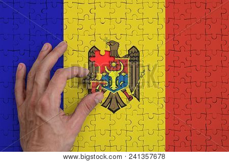 Moldova Flag  Is Depicted On A Puzzle, Which The Man's Hand Completes To Fold