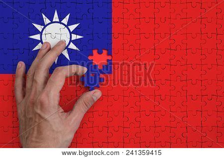 Taiwan Flag  Is Depicted On A Puzzle, Which The Man's Hand Completes To Fold