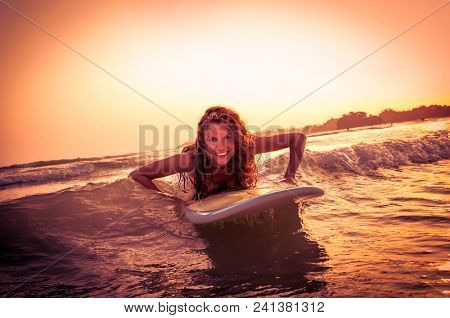 Beautiful surfer on sunset at  Weligama beach , Sri Lanka.  It coast of Indian ocean is the best surf paradise in Sri Lanka