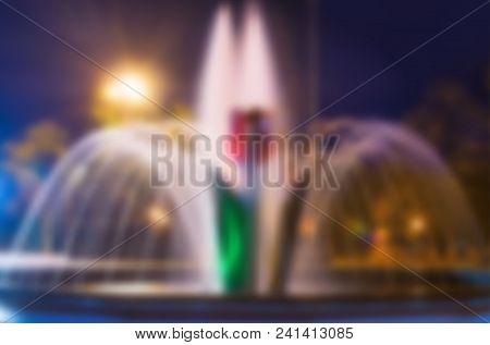 Beautiful Night Blurred Background With Tulip Flower Fountain In Pokrow City Ukraine. City Evening I