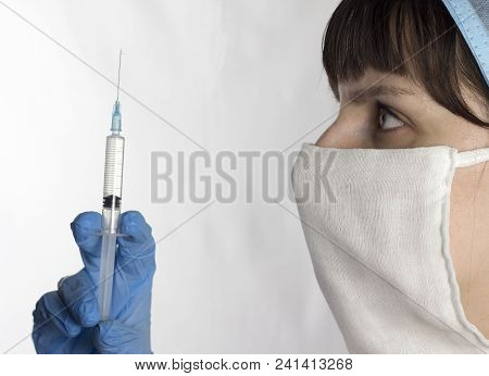 Girl Doctor In Mask And Cap With Syringe In Hands On White Background, Close-up