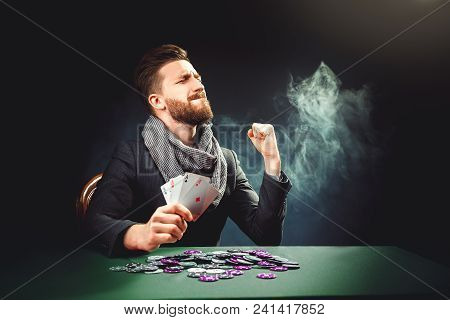 Successful Pocker Player Enjoying His Win At Pocker Table With Chips And Cards