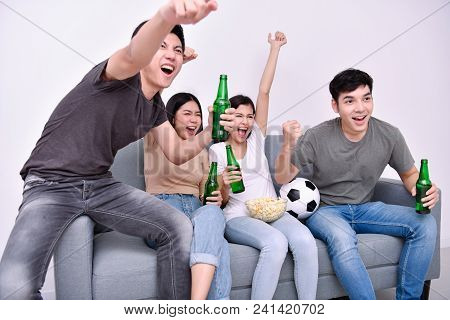 Concept Of Cheering. Asian Teenagers Watching Football On Television. People Are Cheering And Winnin