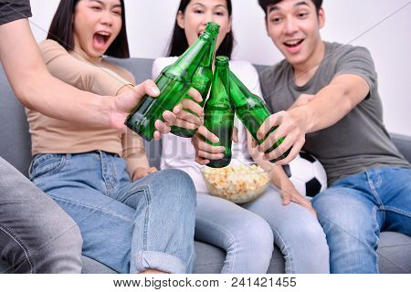 Concept Of Cheering. Asian Teenagers Watching Football On Television. People Are Cheering And Winnin
