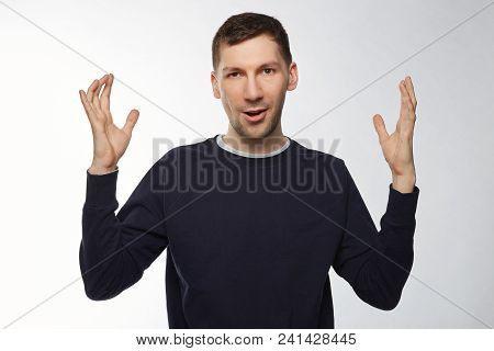 Indoor Studio Shot Of Surprised Male Worker Showing Size Of Fish He Caught. Handsome Powerful Male D
