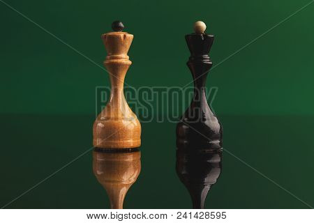 Pair Of Queen Chess Pieces Confronted As Opposites On Green Background With Reflection. Forbidden Lo