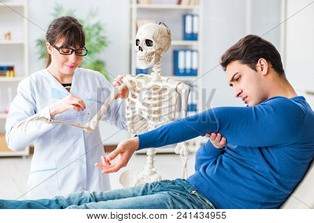 Doctor showing type of injury on skeleton to patient