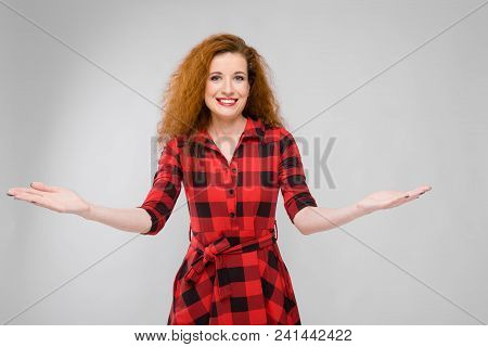 Charming Young Girl In A Checkered Cloth On A Gray Background