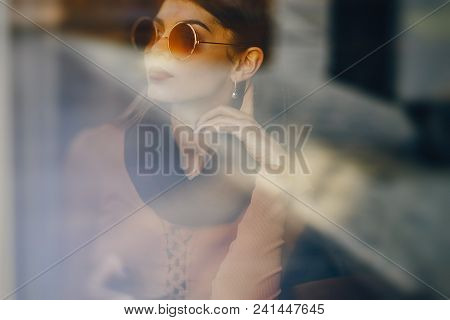 Brunette Girl Using Her Cell Phone While Sitting At A Rastaurant For Lunch