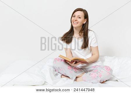 Young Happy Woman Sitting In Bed With White Sheet, Pillow, Blanket On White Background. Beauty Femal