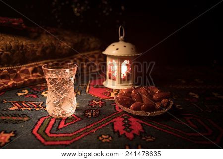 Water And Dates. Iftar Is The Evening Meal. View Of Decoration Ramadan Kareem Holiday On Carpet. Fes