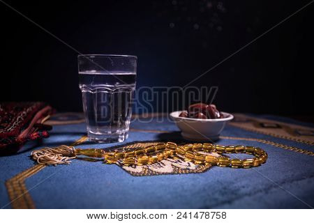 Water And Dates. Iftar Is The Evening Meal. View Of Decoration Ramadan Kareem Holiday On Carpet. Fes