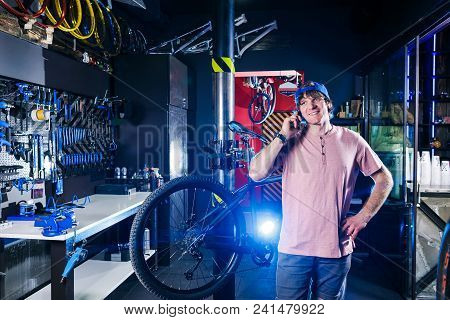 Theme Is Small Business. Portrait Of A Young Man The Owner Of A Bicycle Workshop For Repair And Main