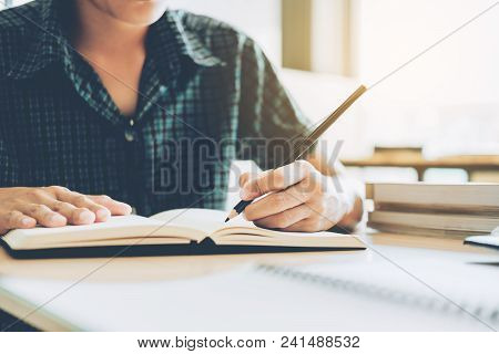 High School Or College Student Studying And Reading In Library