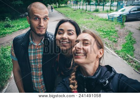 A Guy With A Girl Taking Selfies On A Street Background