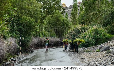 Tibetan People Walking On Rural Road
