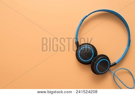 Flat Lay, Top View Of Blue Headphones On Brown Color Background With Coyspace.place For Text.