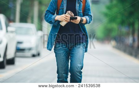 Walking With Coffee Themo Cup In Hand And Use Cellphone On City Street