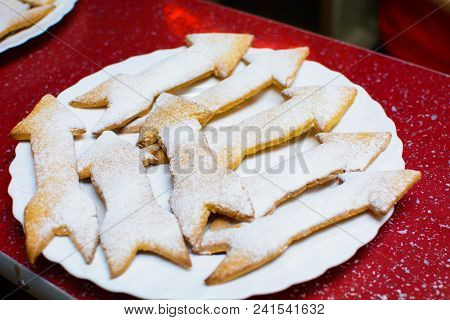 Many Cookies In The Form Of Arrows On A Plate.