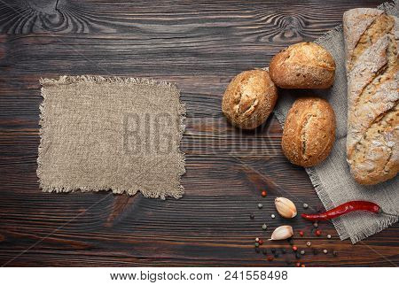 A Set Of Bread, Pepper, Garlic On A Brown Wooden Board
