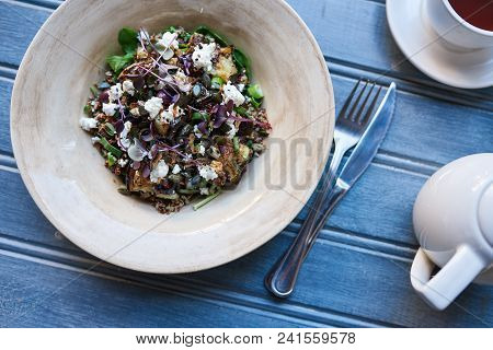 High Angle Of A Healthy Salad Of Mixed Organic Vegetables In A Bowl Next To Cultery And Tea Sitting 