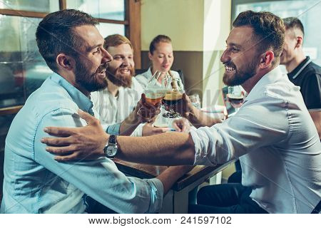 Young Cheerful People Smile And Gesture While Relaxing In Pub. Team Job. Photo Young And Mature Busi