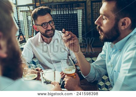 Young Cheerful People Smile And Gesture While Relaxing In Pub. Team Job. Photo Young And Mature Busi