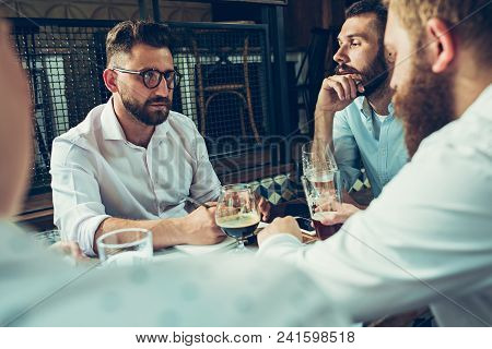Young Cheerful People Smile And Gesture While Relaxing In Pub. Team Job. Photo Young And Mature Busi