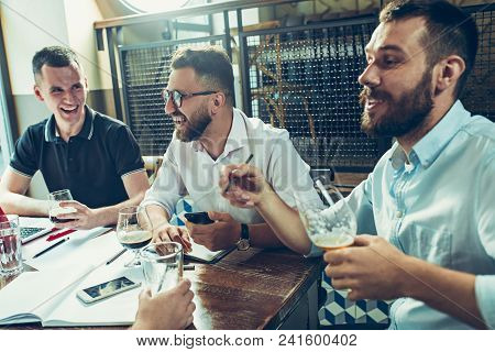 Young Cheerful People Smile And Gesture While Relaxing In Pub. Team Job. Photo Young And Mature Busi