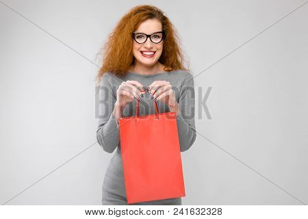 Charming Young Girl With Red Hair. A Young Girl In A Gray Sweater. Young Girl On A Gray Background.