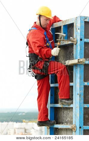 worker mounter assembling concrete form work at construction site