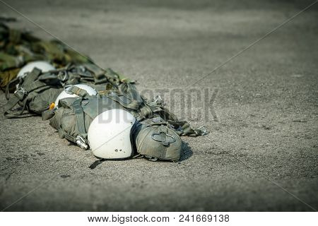 Row Of T-10 Tactical Parachute Bag With Parachute Reserve And Helmet On Ground Prepare For Paratroop
