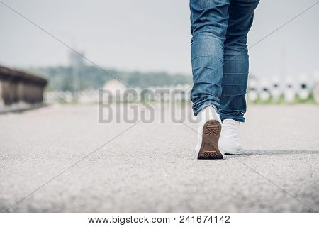 Close Up Woman Wear Jean And White Sneaker Walking Forward On Highway Road In Sunny Day,alone Travel