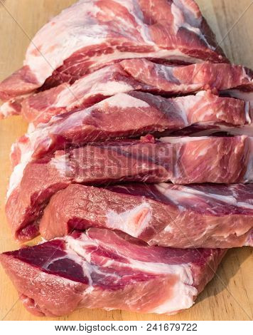 Overhead View Of Raw Cuting Pieces Of Pork On Wooden Background. Piece Of Fresh Boneless Pork, Neck 