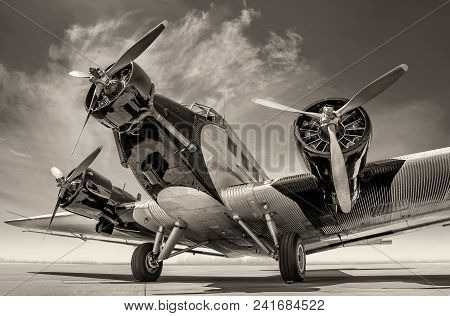 Historical Aircraft On An Airfield Against A Cloudy Sky