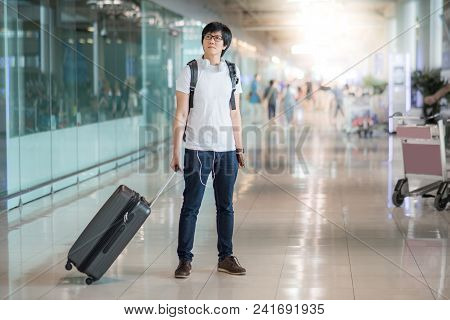 Young Asian Man Dressed In Casual Style Walking With Suitcase Luggage In The International Airport T