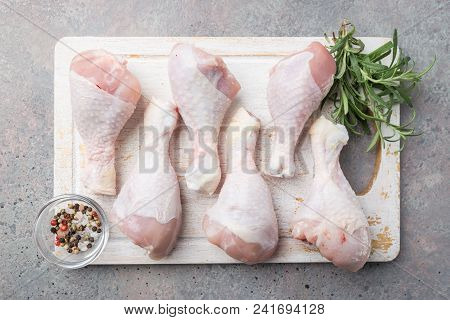 Raw Chicken Legs With Herbs And Spices On Cutting Board. Top View. Gray Background