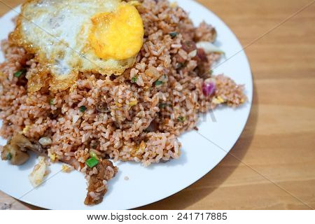 Pork Fried Rice With Spiegelei Egg On White Plate Wooden Table