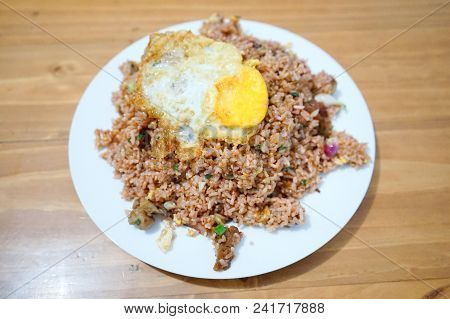 Pork Fried Rice With Spiegelei Egg On White Plate Wooden Table