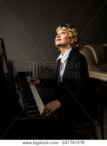 Beautiful Woman In A Business Suit Playing The Piano