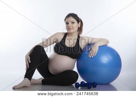 Pregnant Woman Is Doing Exercises With Gymnastic Ball On White Background
