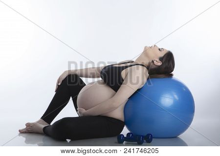 Pregnant Woman Is Doing Exercises With Gymnastic Ball On White Background
