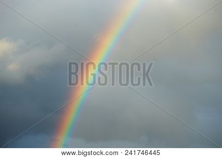 A Bright Rainbow On A Dark Stormy Sky.